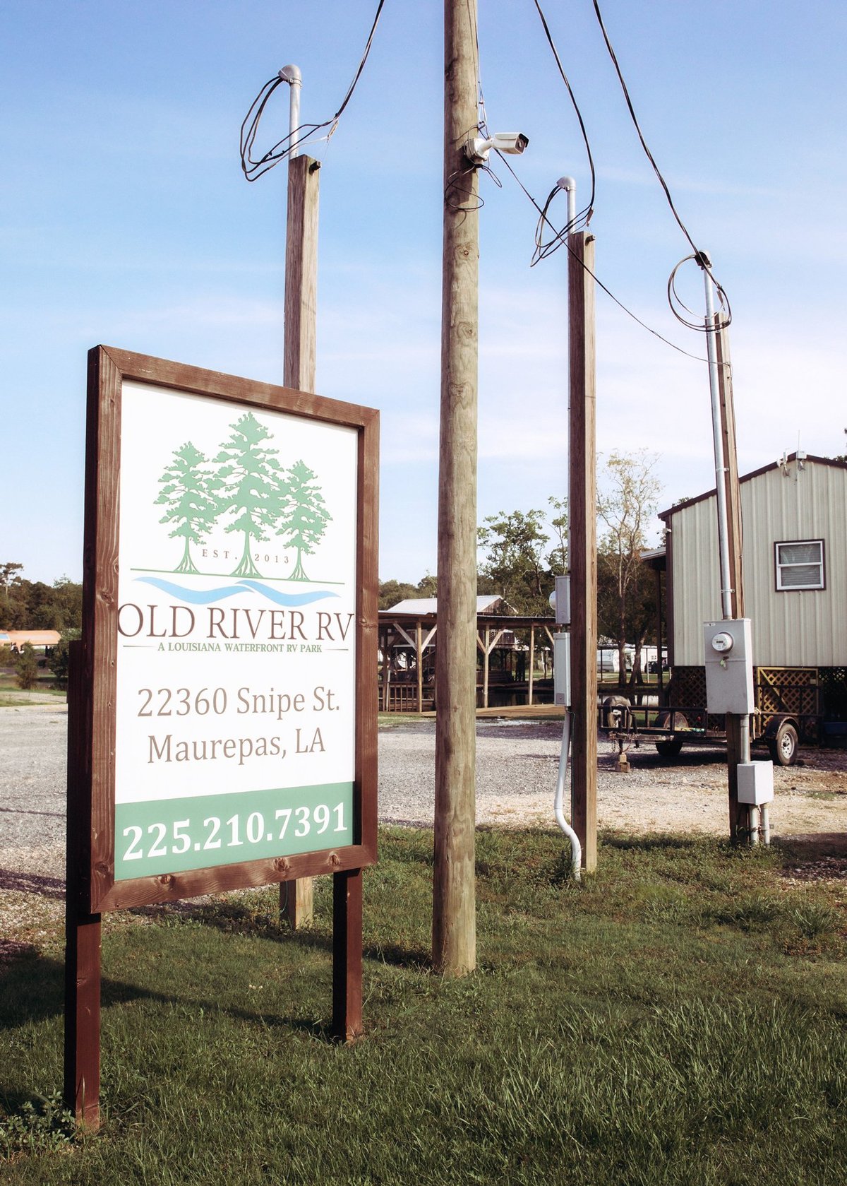 Old River RV park wooden sign showing address and phone number